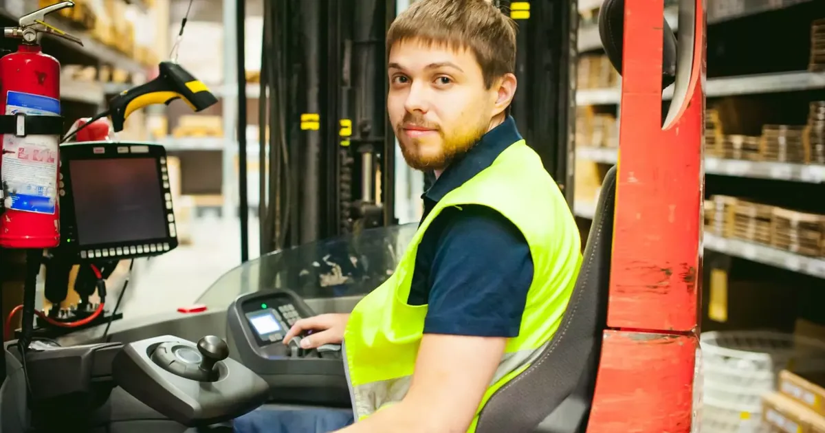 Staplerfahrer mit Terminal und Handscanner im Lager