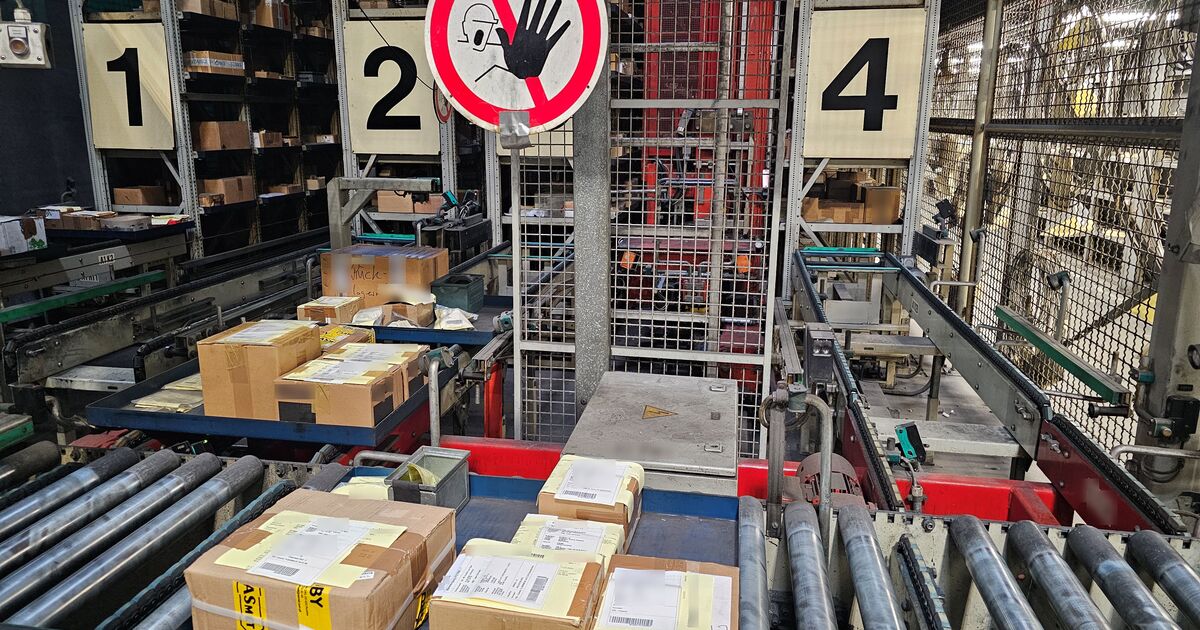 Kommissionierplätze an einem automatischen Tablarlager mit Kartons auf der Fördertechnik